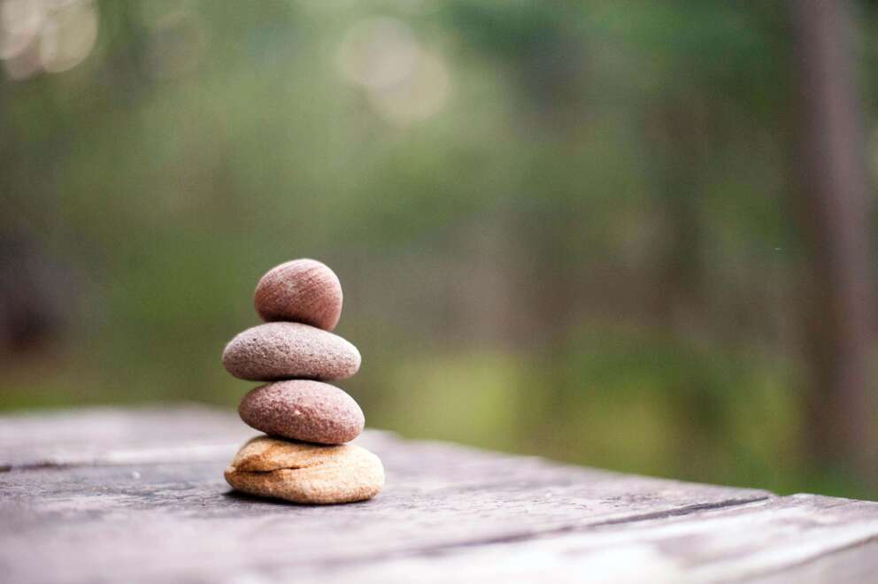 Stapel steentjes op tafel als symbool voor de gezonde houding bij Qigong