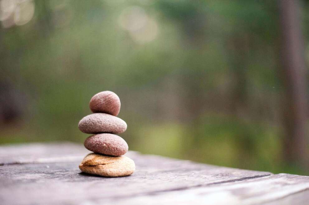 Stapel steentjes op tafel als symbool voor de gezonde houding bij Qigong